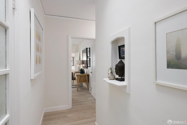 hallway featuring light wood-type flooring and baseboards