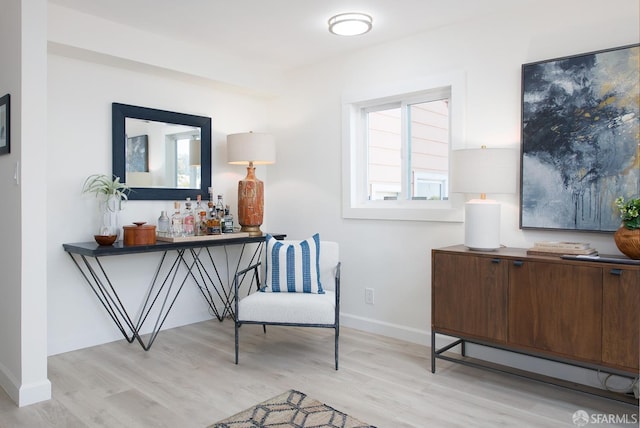 sitting room with baseboards and wood finished floors