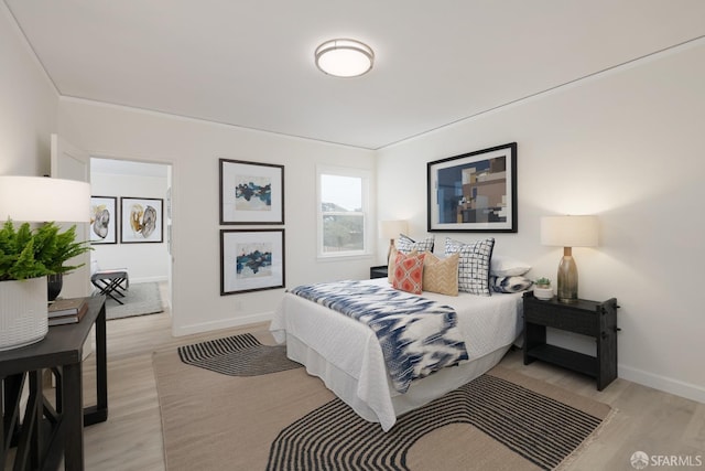 bedroom featuring light wood-type flooring and baseboards