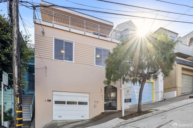 view of front of home featuring a garage and a balcony