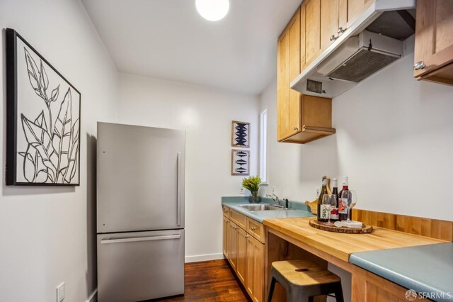 kitchen with stainless steel refrigerator, dark hardwood / wood-style flooring, and sink