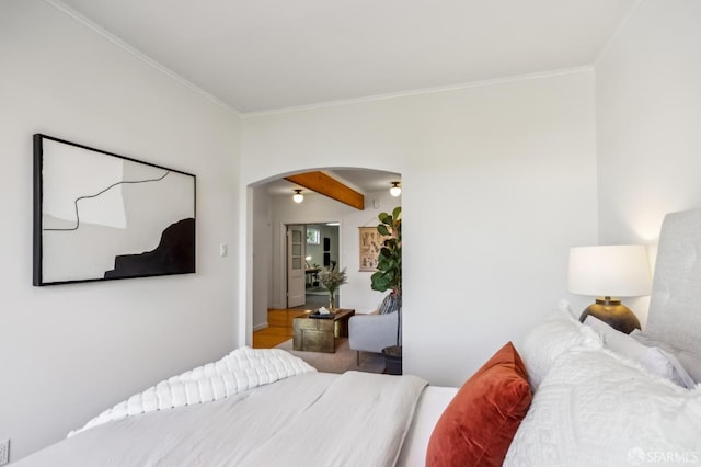 bedroom with beam ceiling and ornamental molding