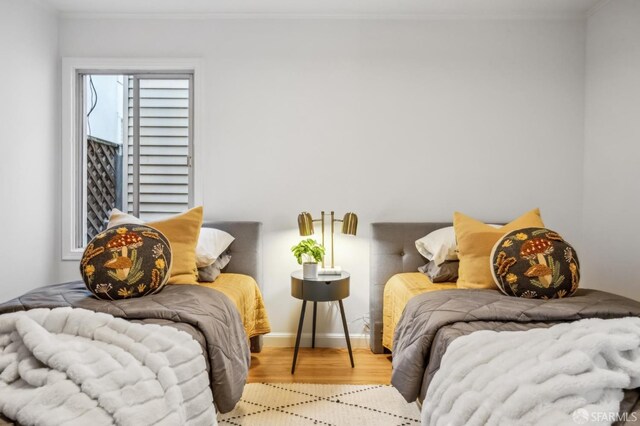 bedroom featuring crown molding and light wood-type flooring