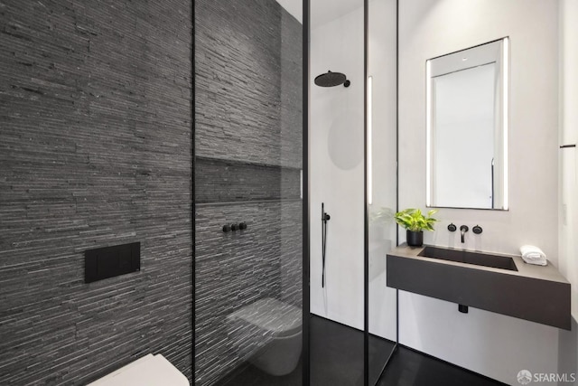 bathroom featuring a tile shower and toilet