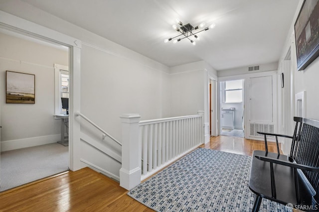 207 Eureka St, San Francisco, CA 94114 - hallway featuring an upstairs landing, wood finished floors, baseboards, and a chandelier