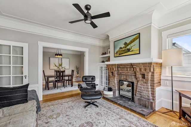 207 Eureka St, San Francisco, CA 94114 - living room with wood finished floors, ornamental molding, a ceiling fan, built in features, and a brick fireplace