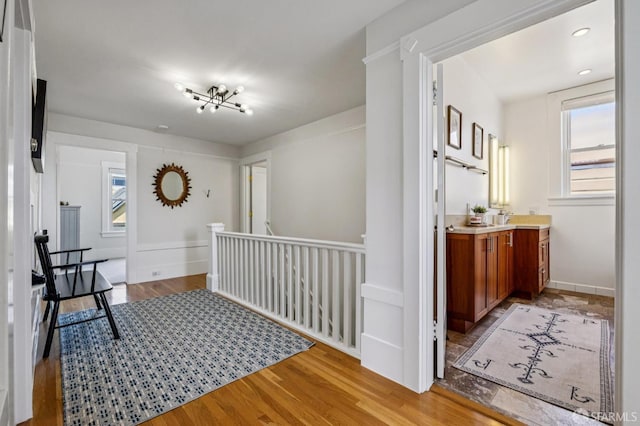 207 Eureka St, San Francisco, CA 94114 - hallway with light wood finished floors, an upstairs landing, and a chandelier