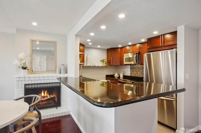 360 Guerrero St Unit 408, San Francisco, CA 94103 - kitchen featuring recessed lighting, a peninsula, stainless steel appliances, a fireplace, and light wood-type flooring