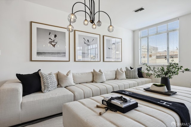 living area featuring visible vents and an inviting chandelier