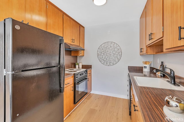 1734 Bay St Unit 103, San Francisco, CA 94123 - kitchen with freestanding refrigerator, electric stove, under cabinet range hood, light wood finished floors, and dark countertops