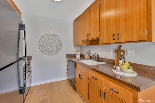 1734 Bay St Unit 103, San Francisco, CA 94123 - kitchen featuring freestanding refrigerator, dishwasher, light wood finished floors, dark countertops, and brown cabinetry