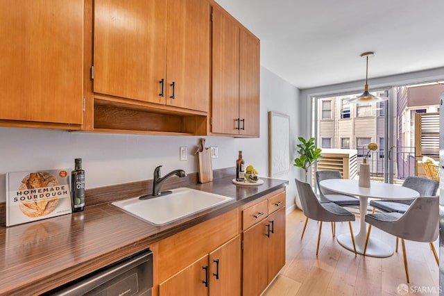 1734 Bay St Unit 103, San Francisco, CA 94123 - kitchen with dark countertops, dishwasher, light wood finished floors, and decorative light fixtures