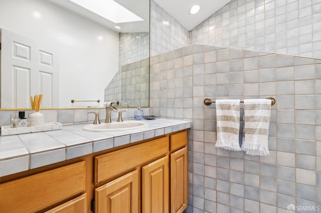 744 Crompton Rd, Redwood City, CA 94061 - bathroom with a skylight, vanity, tile walls, vaulted ceiling, and recessed lighting