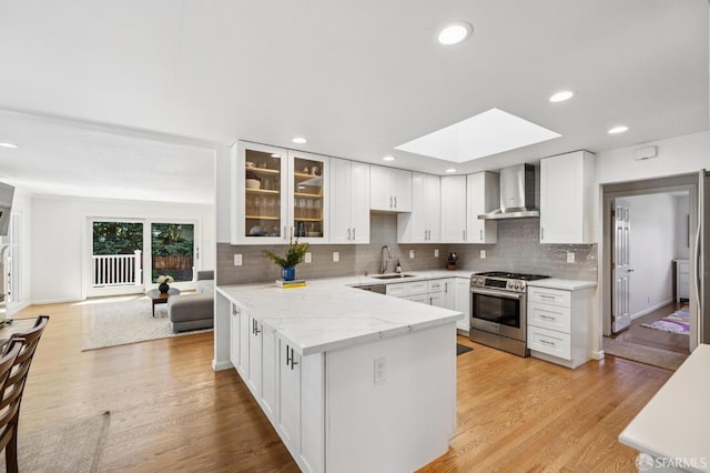 744 Crompton Rd, Redwood City, CA 94061 - kitchen with stainless steel range with gas cooktop, wall chimney exhaust hood, a skylight, a peninsula, and glass insert cabinets