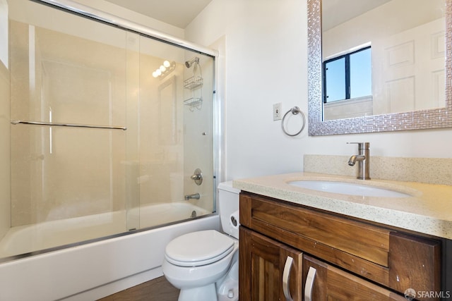 full bathroom featuring vanity, shower / bath combination with glass door, and toilet