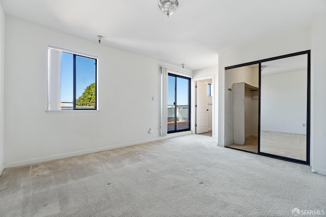 unfurnished bedroom with multiple windows and light colored carpet