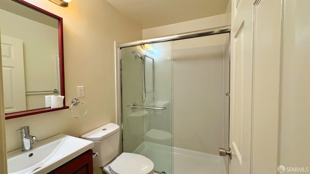 bathroom with vanity, a shower with shower door, and toilet