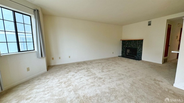 unfurnished living room with light colored carpet and a fireplace