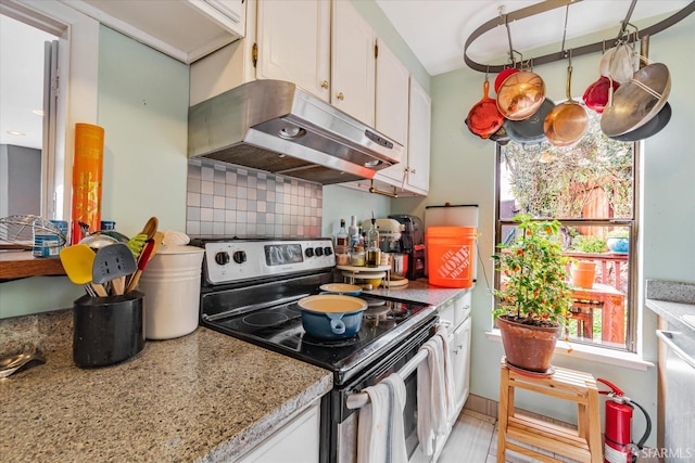 kitchen with tasteful backsplash, white cabinets, appliances with stainless steel finishes, light stone countertops, and under cabinet range hood