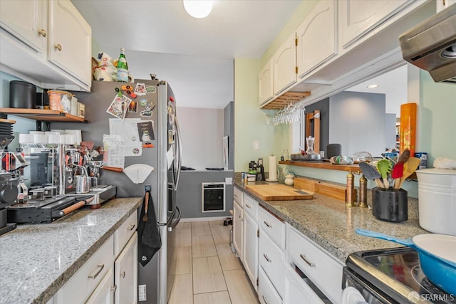 kitchen with heating unit, light stone counters, and white cabinets