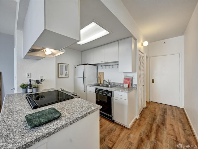 kitchen featuring white cabinetry, sink, light stone counters, black appliances, and light wood-type flooring