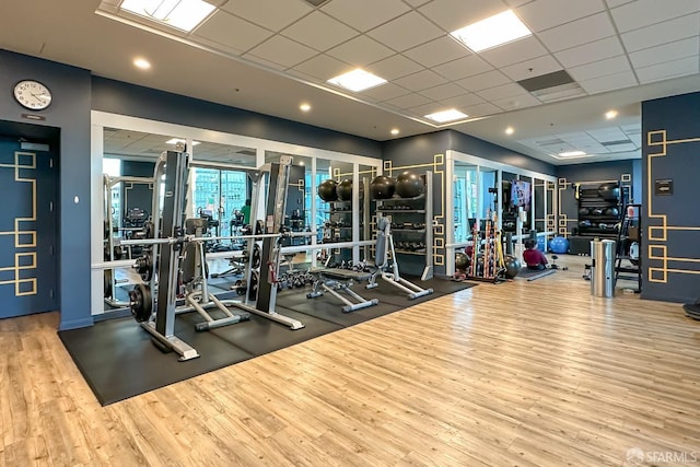 exercise room featuring hardwood / wood-style flooring and a paneled ceiling