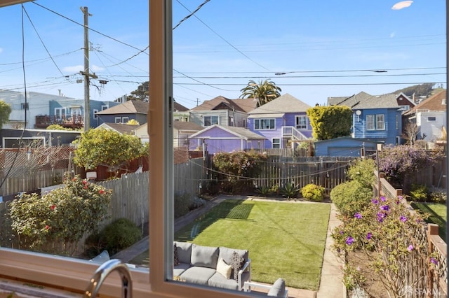 view of yard featuring a residential view, a fenced backyard, and an outdoor living space