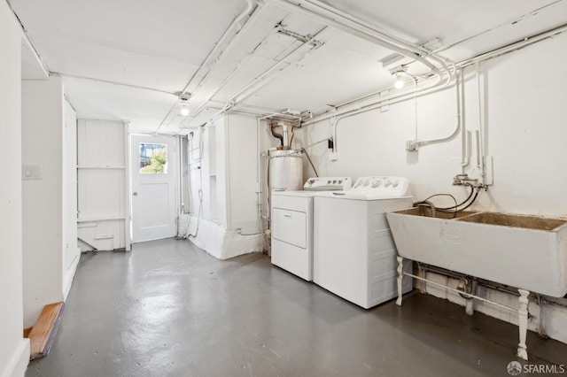 washroom with a sink, laundry area, gas water heater, and washing machine and dryer