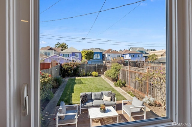 view of yard featuring a residential view, a fenced backyard, and an outdoor living space