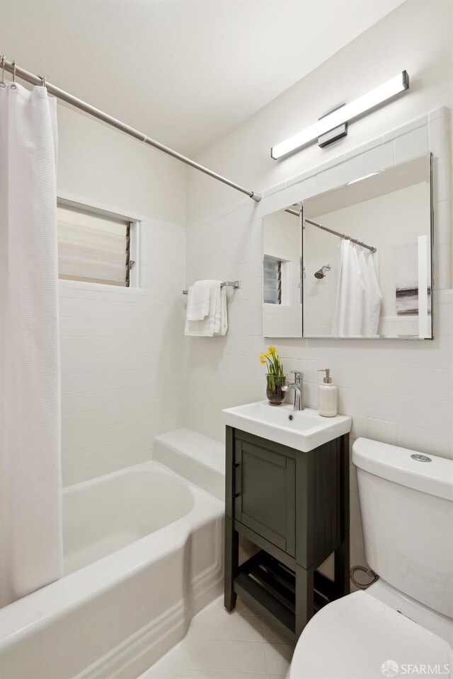 full bath with toilet, tile patterned floors, shower / bathtub combination with curtain, and vanity