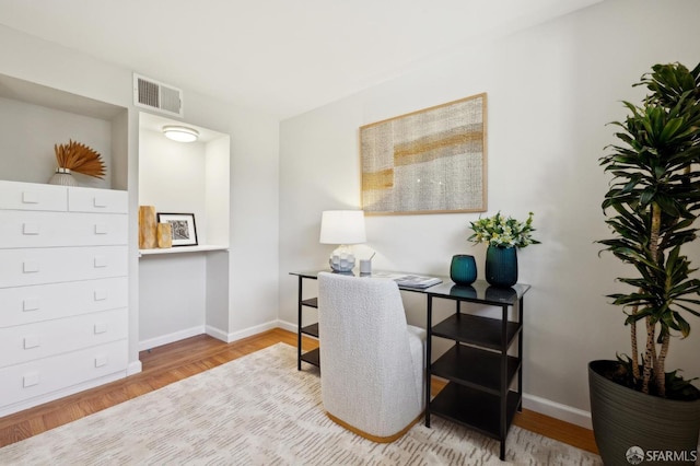 office area featuring visible vents, baseboards, and wood finished floors