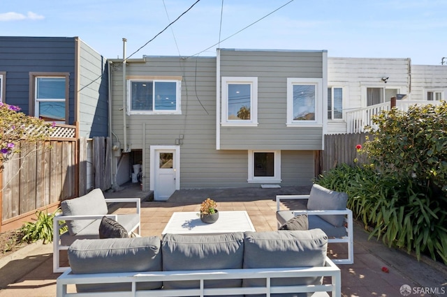 back of property with a patio, outdoor lounge area, and fence