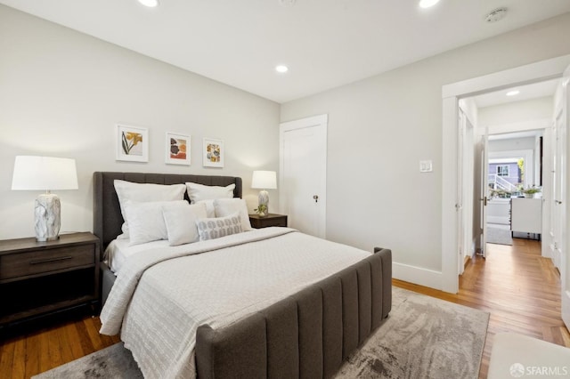 bedroom with light wood-type flooring, baseboards, and recessed lighting