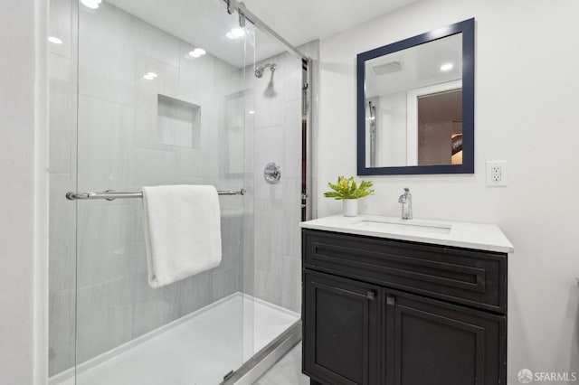 bathroom with a shower stall, visible vents, and vanity