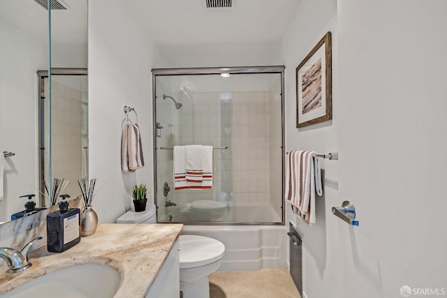 full bathroom with toilet, combined bath / shower with glass door, visible vents, and vanity