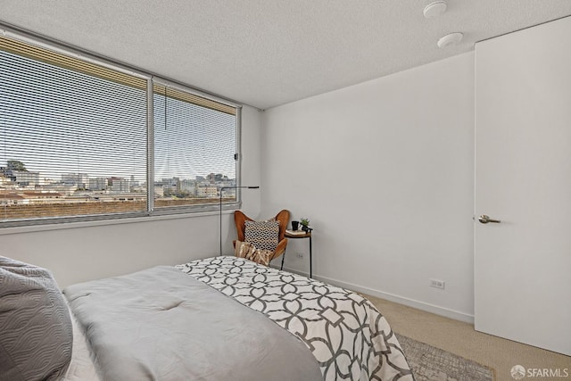 carpeted bedroom with a textured ceiling and baseboards