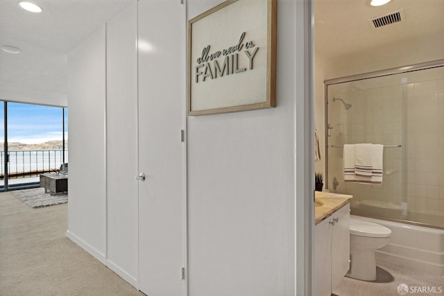 bathroom with enclosed tub / shower combo, toilet, recessed lighting, vanity, and visible vents