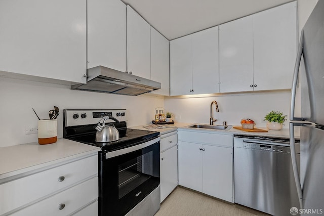 kitchen featuring stainless steel appliances, light countertops, white cabinetry, a sink, and under cabinet range hood