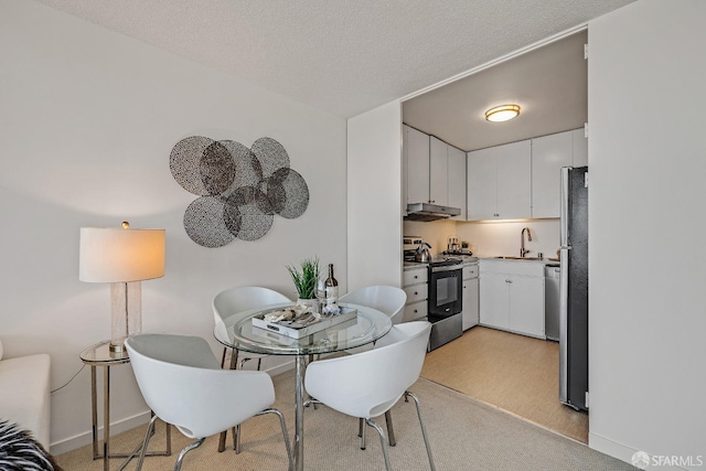 dining space with a textured ceiling and baseboards