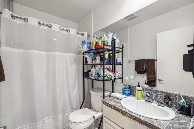 bathroom with walk in shower, vanity, and toilet