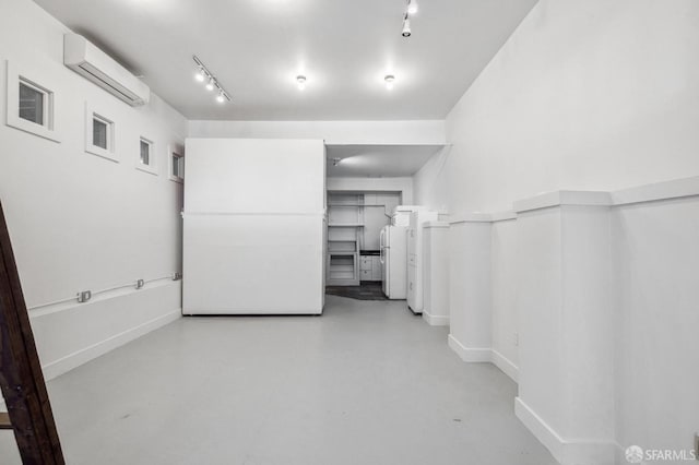 interior space featuring concrete flooring and a wall mounted AC