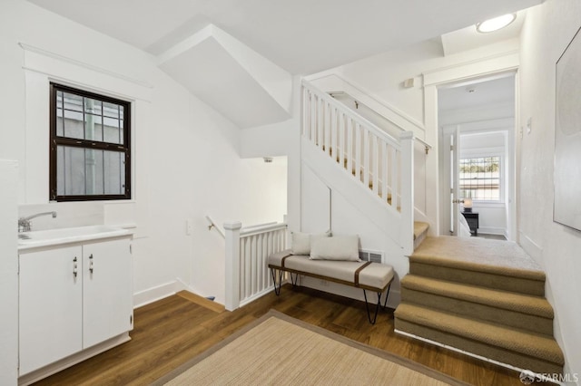 stairs featuring hardwood / wood-style floors and sink