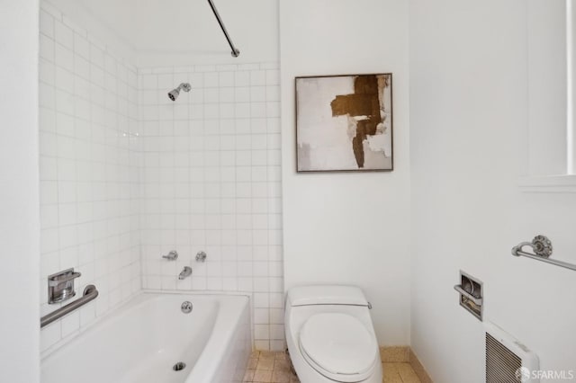 bathroom with tiled shower / bath and toilet