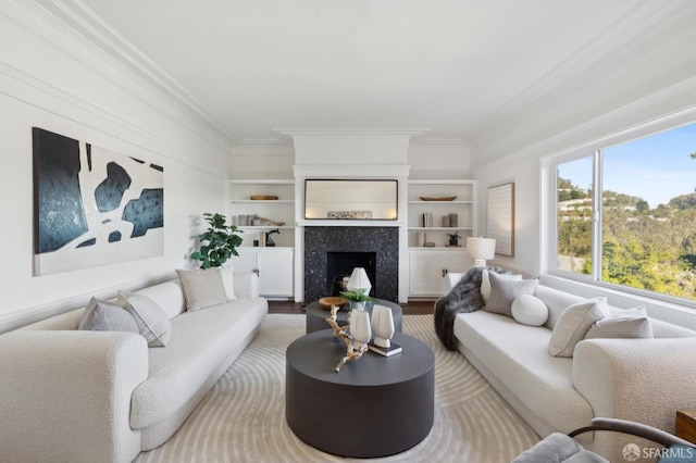 living room featuring a tile fireplace, wood-type flooring, crown molding, and built in shelves