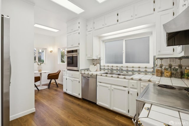 kitchen with dark hardwood / wood-style flooring, sink, white cabinets, and appliances with stainless steel finishes