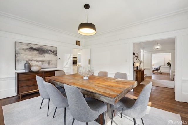 dining area featuring crown molding and dark wood-type flooring