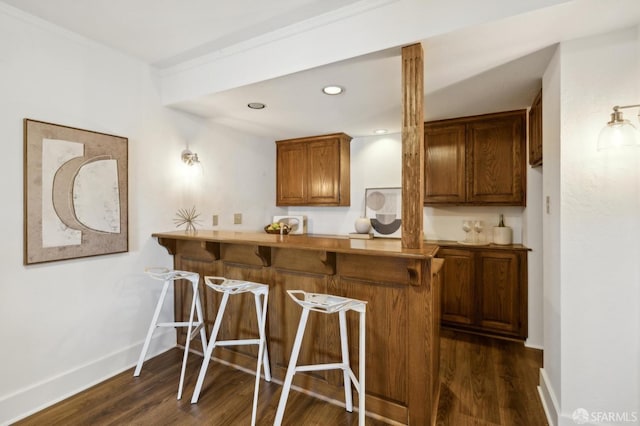 kitchen with dark wood-type flooring, a kitchen breakfast bar, and kitchen peninsula