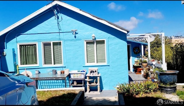 back of property with stucco siding and a patio