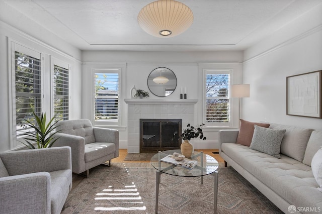 living area with wood finished floors and a tile fireplace