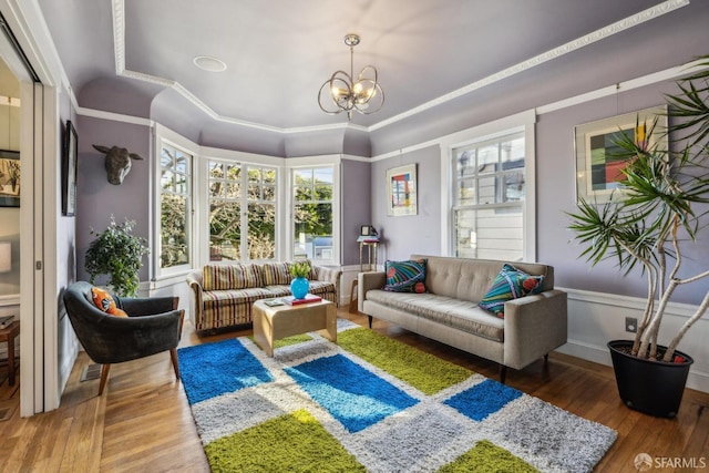 living room featuring hardwood / wood-style floors, a notable chandelier, and ornamental molding